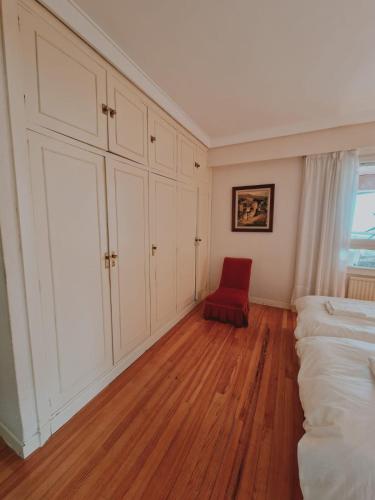 a bedroom with a red chair and a bed at Amplio piso en la playa de 135 m2 con garaje in Zarautz