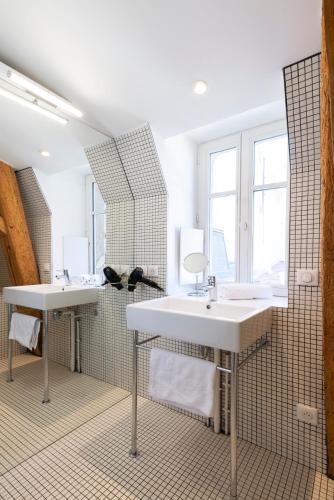 une salle de bain avec deux lavabos et un grand miroir dans l'établissement Le Grand Amerval - Joli appartement climatisé, à Nancy