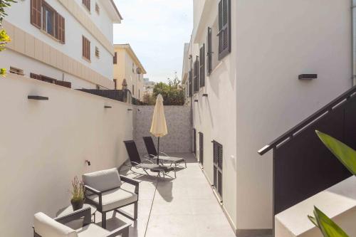 a balcony with chairs and a umbrella on a building at Es descans in Can Picafort