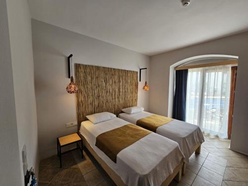 グムベットにあるSerpina Hotelのベッドルーム1室(ベッド2台、大きな窓付)
