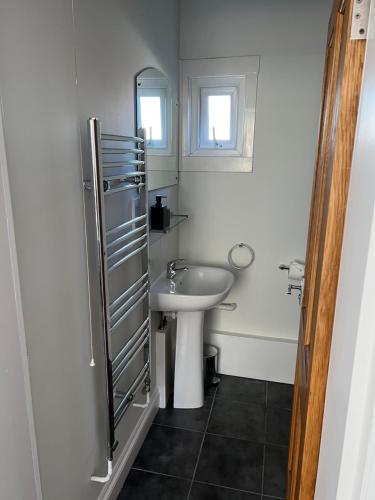 a white bathroom with a sink and a mirror at The Snicket Apartment in Basingstoke