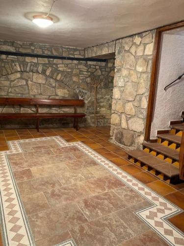 a room with a bench and a stone wall at Cal Bisbe in Segura