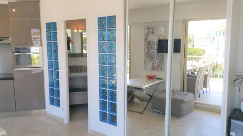 une cuisine avec des portes en verre bleu et une table dans l'établissement La Pinede, à Juan-les-Pins