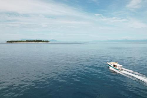 a small boat in the middle of a large body of water at Metita Beach & Dive Resort in Doruba