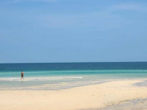 a person standing on a beach in the ocean at Luna Koh Rong in Koh Rong Island