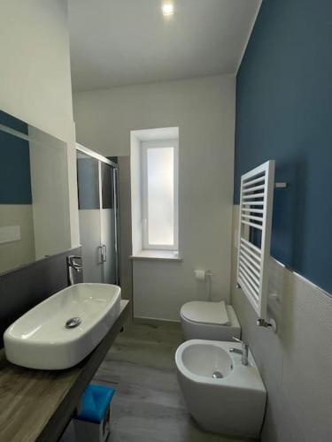 een badkamer met een witte wastafel en een toilet bij Appartamento Il cielo in una stanza- Vista Mare! in Nettuno
