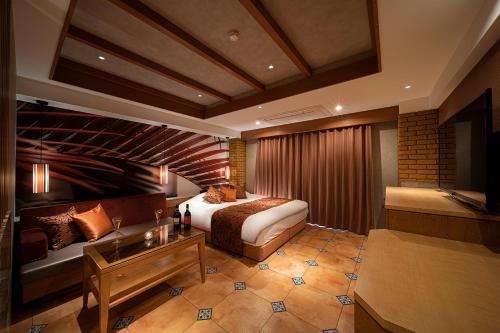 a hotel room with a bed and a couch at ホテル リッド 男塾ホテルグループ in Hikone