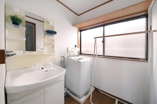 a white bathroom with a sink and a shower at Pirane House 201 東京スカイツリー浅草 押上駅が徒歩圏内 無料wifi in Tokyo