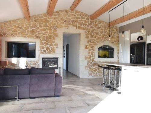 ein Wohnzimmer mit einem Sofa und einer Steinmauer in der Unterkunft Maison Le Cailar, 3 pièces, 4 personnes - FR-1-717-21 in Le Cailar