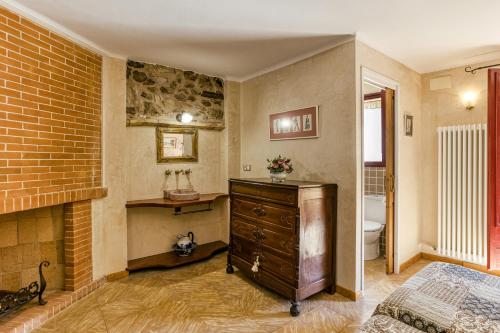 a bedroom with a fireplace and a dresser and a bathroom at Ca La Maria in Orriols