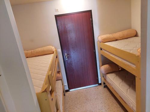 - une porte dans une chambre avec 2 lits superposés dans l'établissement Studio double cabine RDJ avec loggia et jardinet, parking privé, 5 pers - La Grande-Motte - FR-1-716-26, à La Grande Motte