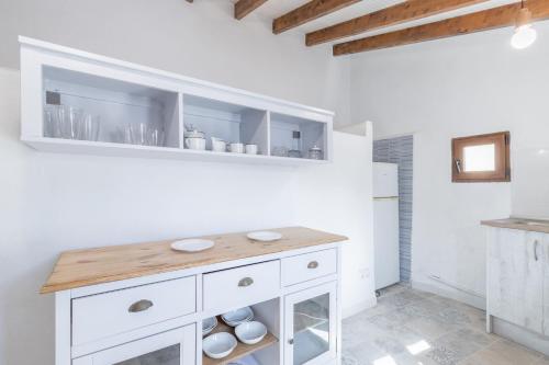 a kitchen with white cabinets and a wooden counter at La Cambra de la Clau in Polop