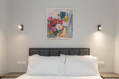 a bedroom with a bed with a painting on the wall at Palm Side Hotel in Vlorë