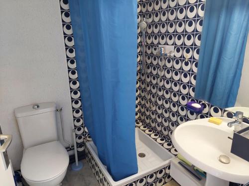 La salle de bains est pourvue de toilettes, d'un lavabo et d'un rideau de douche bleu. dans l'établissement Studio équipé au port de La Grande-Motte - FR-1-716-24, à La Grande Motte