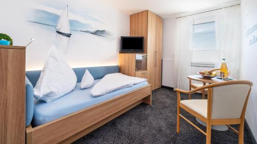 a room with a bed and a table and a chair at Ferienhof Berger UG in Hagnau