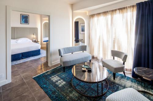 una camera d'albergo con letto, tavolo e sedie di Grand Hotel Diana Majestic a Diano Marina