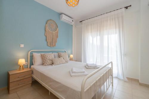 a bedroom with a bed with a blue wall at M-Home, My Paradise Home in Neos Marmaras