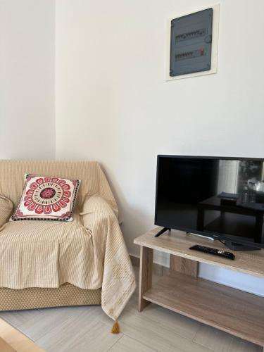 a living room with a couch and a television on a table at River Home in Agia Galini