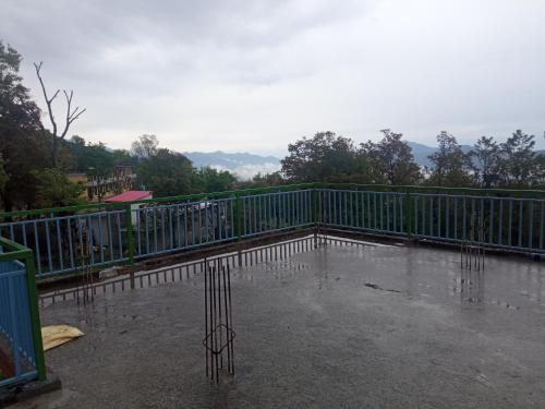 a metal fence with water on the ground at Travelodge Homestay in Bīr