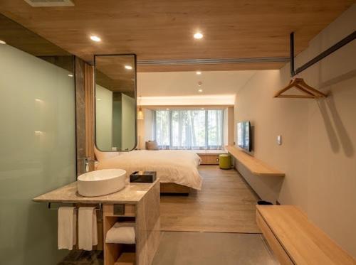 鹿谷的住宿－溪頭福華渡假飯店，一间带水槽的浴室和一张带镜子的床