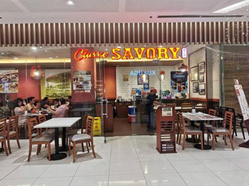 a restaurant with tables and chairs and a sign that reads cuisineagency at Love@Grace Residences near BGC. in Manila
