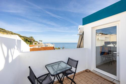 a balcony with chairs and a view of the ocean at Casa Da Paz in Salema