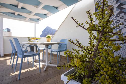 eine Terrasse mit einem Tisch, Stühlen und einer Pflanze in der Unterkunft Acquarò Suite Jacuzzi in San Vito lo Capo