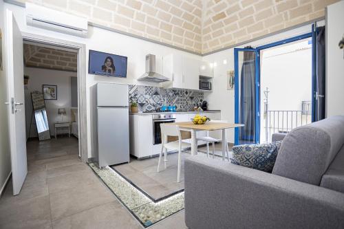 a kitchen and living room with a couch and a table at Acquarò Suite in San Vito lo Capo