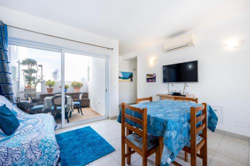 a living room with a dining room table and a television at Casa Da Paz in Salema