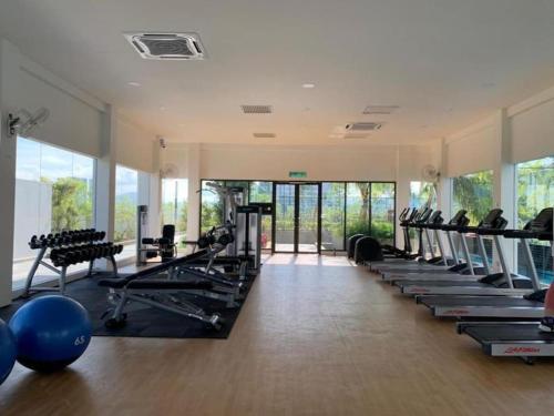 a gym with treadmills and exercise equipment and windows at Traders garden c180 in Cheras