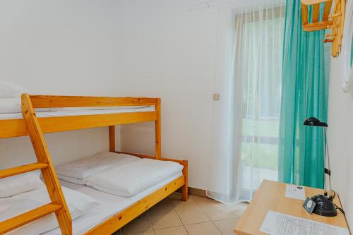 a small room with a bunk bed and a desk at Brzozowa Oaza in Mrzeżyno