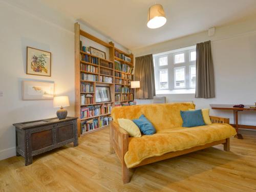 a living room with a couch and a book shelf at School House in Ivybridge