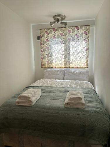 a bedroom with a bed with two towels on it at Spacious Double room for single room in London