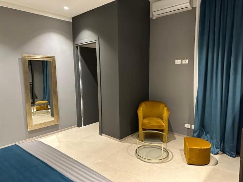 a bedroom with a bed and a chair and a mirror at Suite Apollinare in Ravenna
