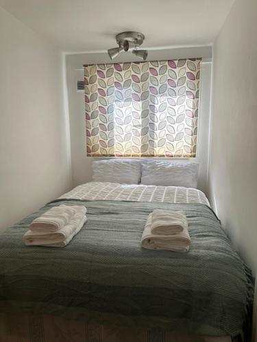 a bedroom with a bed with two towels on it at Spacious Double room for single room in London