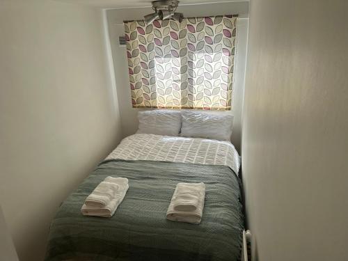 a small bed in a small room with towels on it at Spacious Double room for single room in London