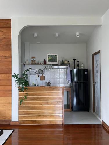 a kitchen with a black refrigerator and a counter at Baan Jai Klang (บ้านใจกลาง) in Chiang Rai