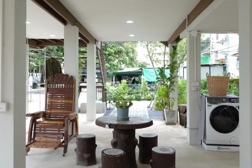 eine Veranda mit einem Tisch und einer Waschmaschine in der Unterkunft Baan Jai Klang (บ้านใจกลาง) in Chiang Rai
