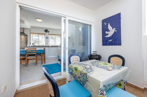 a dining room with a table and chairs and a kitchen at Casa Da Paz in Salema