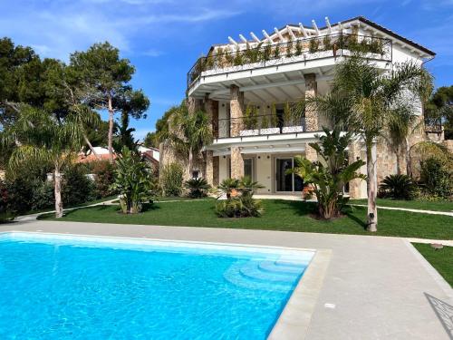 uma casa com uma piscina em frente em Villa Aquamarina Pavoncella Rossa em Porto Pino