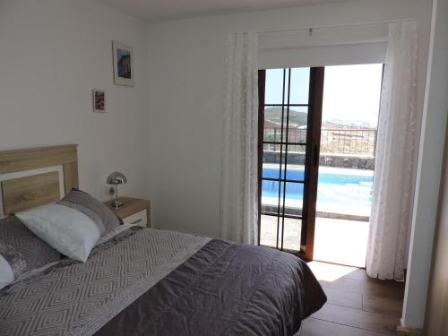 um quarto com uma cama e vista para uma piscina em Arbinfo Casa Rural em Guía de Isora