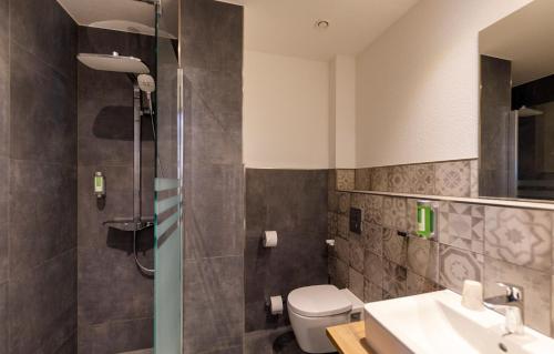 a bathroom with a shower and a toilet and a sink at Kedi Hotel Papenburg in Papenburg