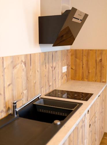 a kitchen with a stove top oven next to a counter at Kedi Hotel Papenburg in Papenburg
