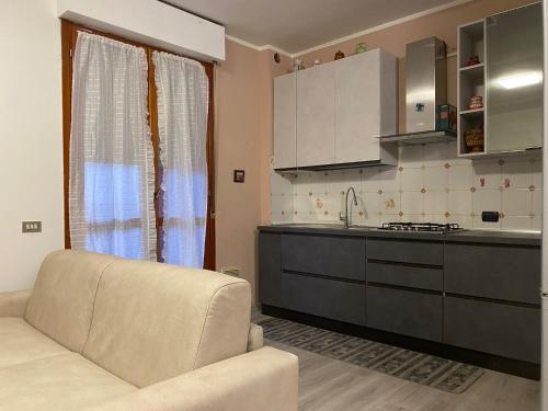 Una sala de estar con un sofá y una cocina. en Rho Fiera Apartment, en Rho