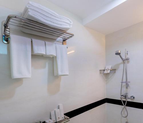 Beehive Central في مدينة ماليه: حمام به مناشف بيضاء معلقة على الحائط