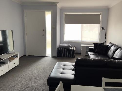 a living room with a couch and a television at Kulin Erindale Apartments in Kulin