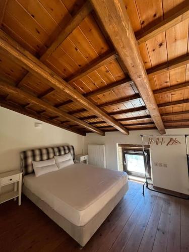 1 dormitorio con 1 cama grande y techo de madera en Cozy village house in Ano Asites, en Áno Asítes