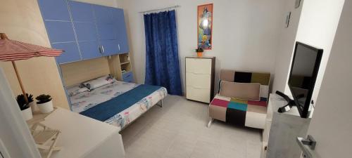 Schlafzimmer mit einem Bett, einem Schreibtisch und einem TV in der Unterkunft Bilocale nel cuore di Sanremo in Sanremo