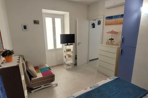Zimmer mit einem Schlafzimmer mit einem Bett und einem Stuhl in der Unterkunft Bilocale nel cuore di Sanremo in Sanremo