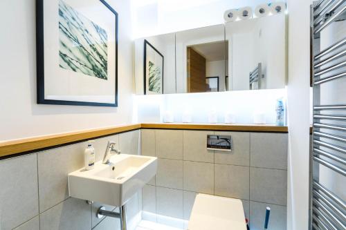 La salle de bains est pourvue d'un lavabo et d'un miroir. dans l'établissement Apartment for 4 in the Heart of Shoreditch, à Londres